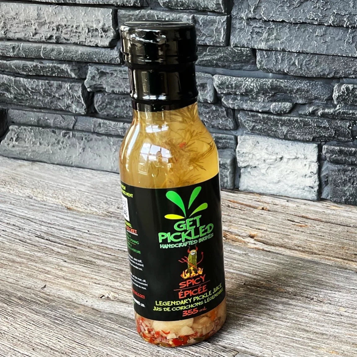 Spicy Get Pickled brine bottle on a wooden tabletop